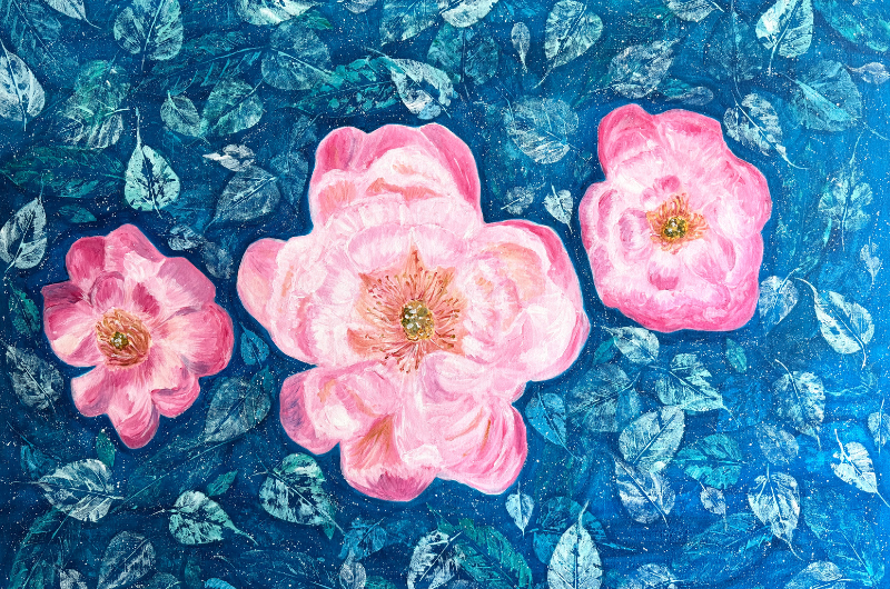 Close up of painting of pink flowers on a blue foliage background