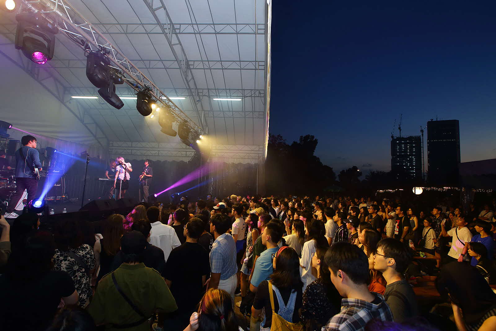 Photograph of audience watching people singing on stage