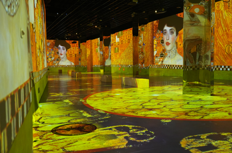 Room with Gustav Klimt paintings projected onto the walls