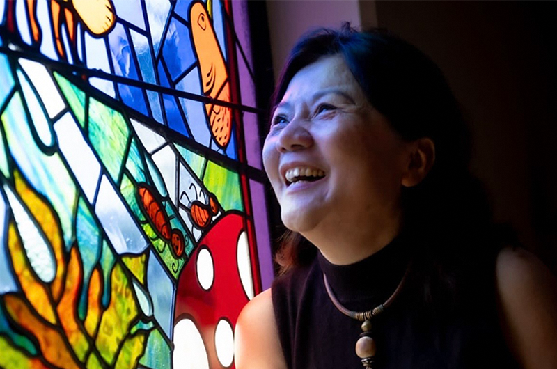 Image of woman smiling at stained glass window