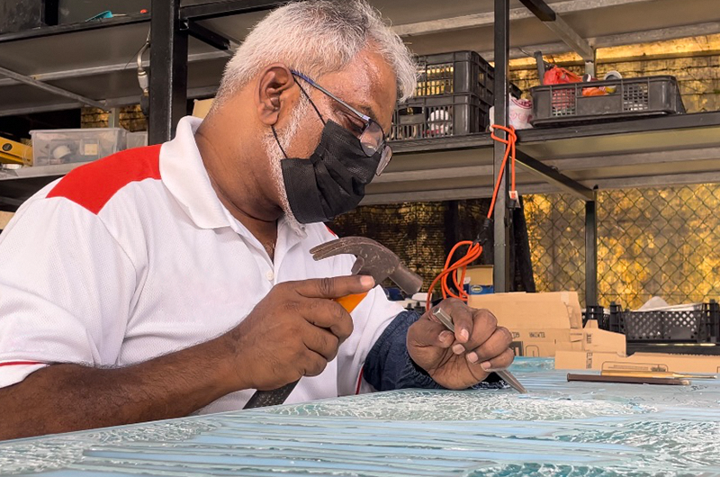 Image of man in a mask sculpting glass