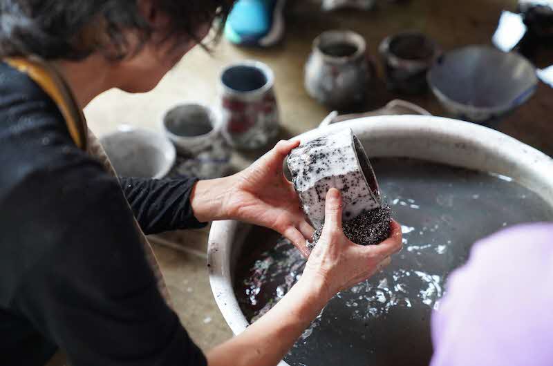 Image of person moulding and rinsing clay