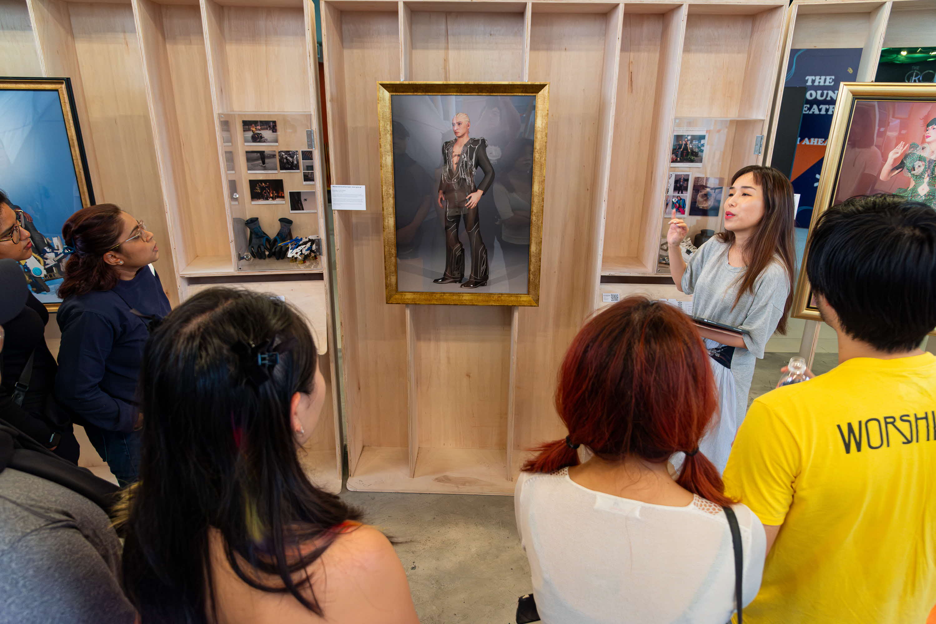 Image of tour guide talking to a group of people about a painting on the wall