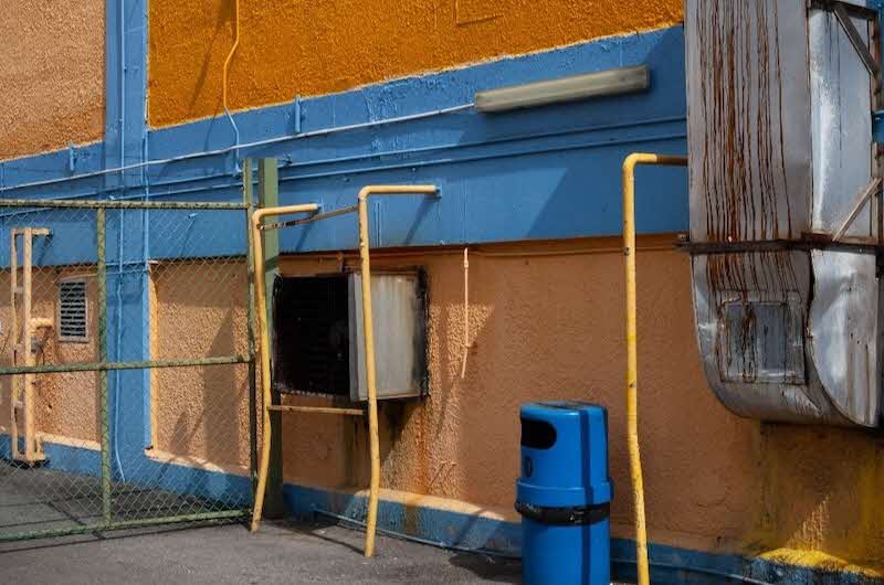 Image of outdoor air conditioning vents on an orange and blue wall