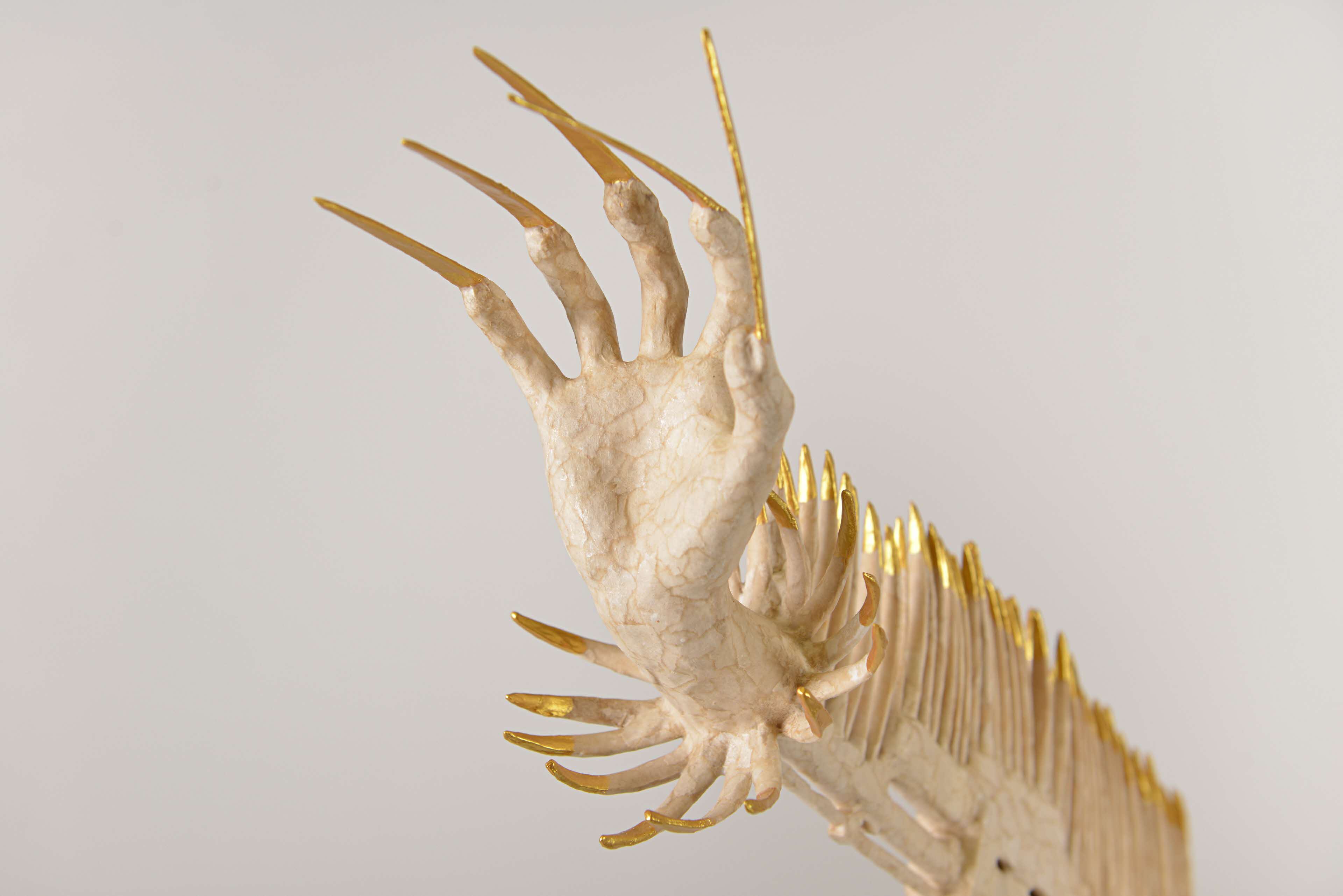 Image of sculpture that has fingers with long claws emerging from all sides