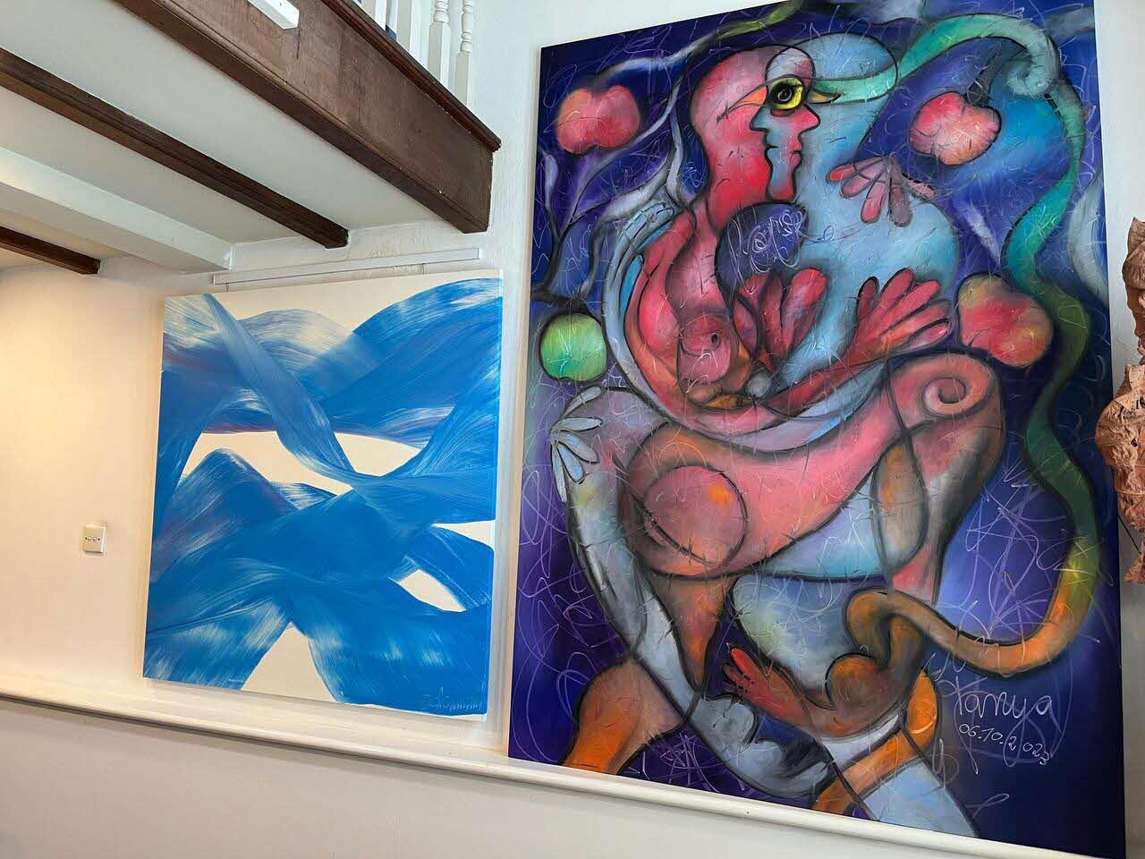 Two large artworks hanging side by side on the wall