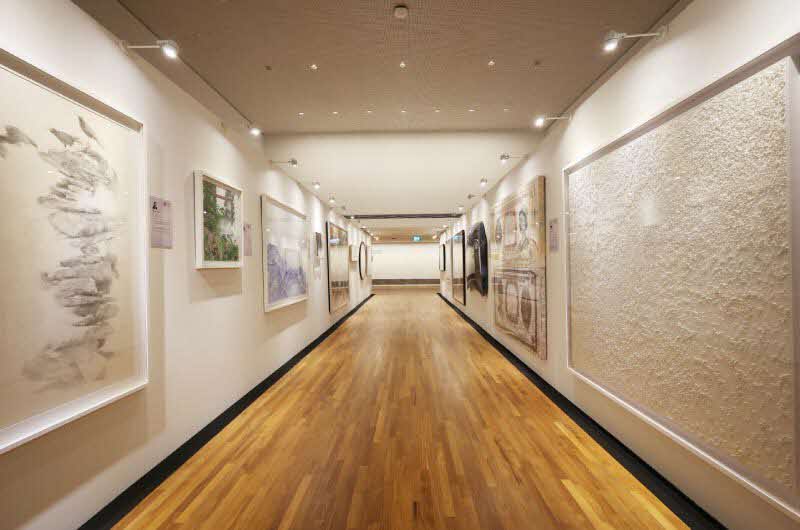 Image of a corridor flanked by paintings on both walls