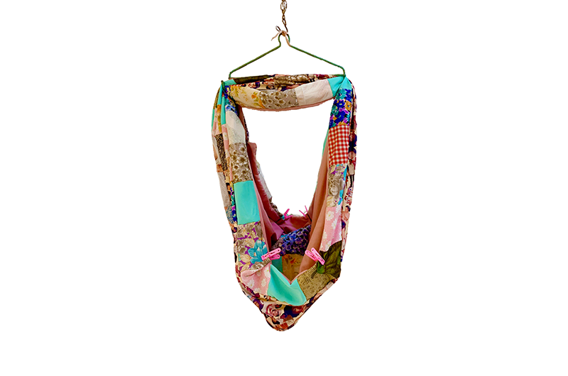 Image of a colourful mixed material scarf on a wire hanger