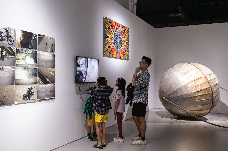 Image of a family looking at the artwork on the wall