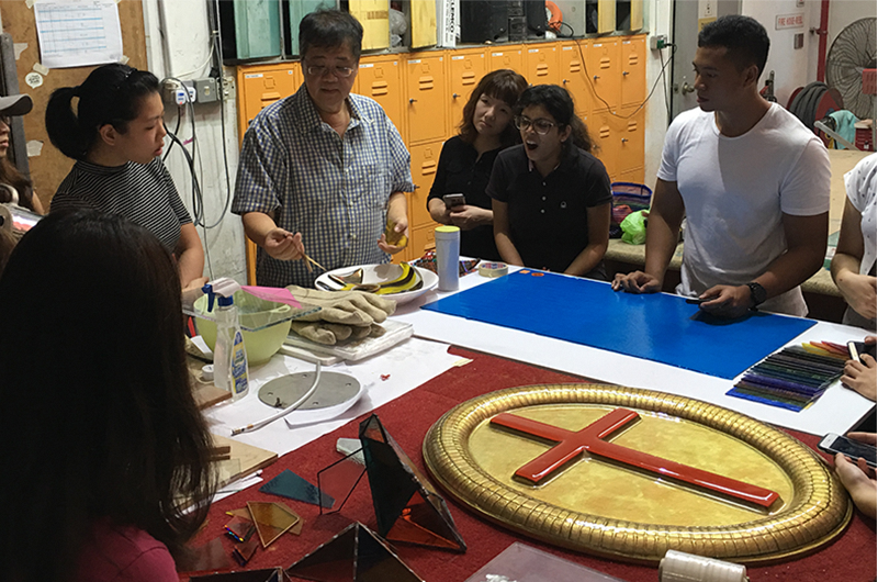 Image of participants at a workshop gathering around materials