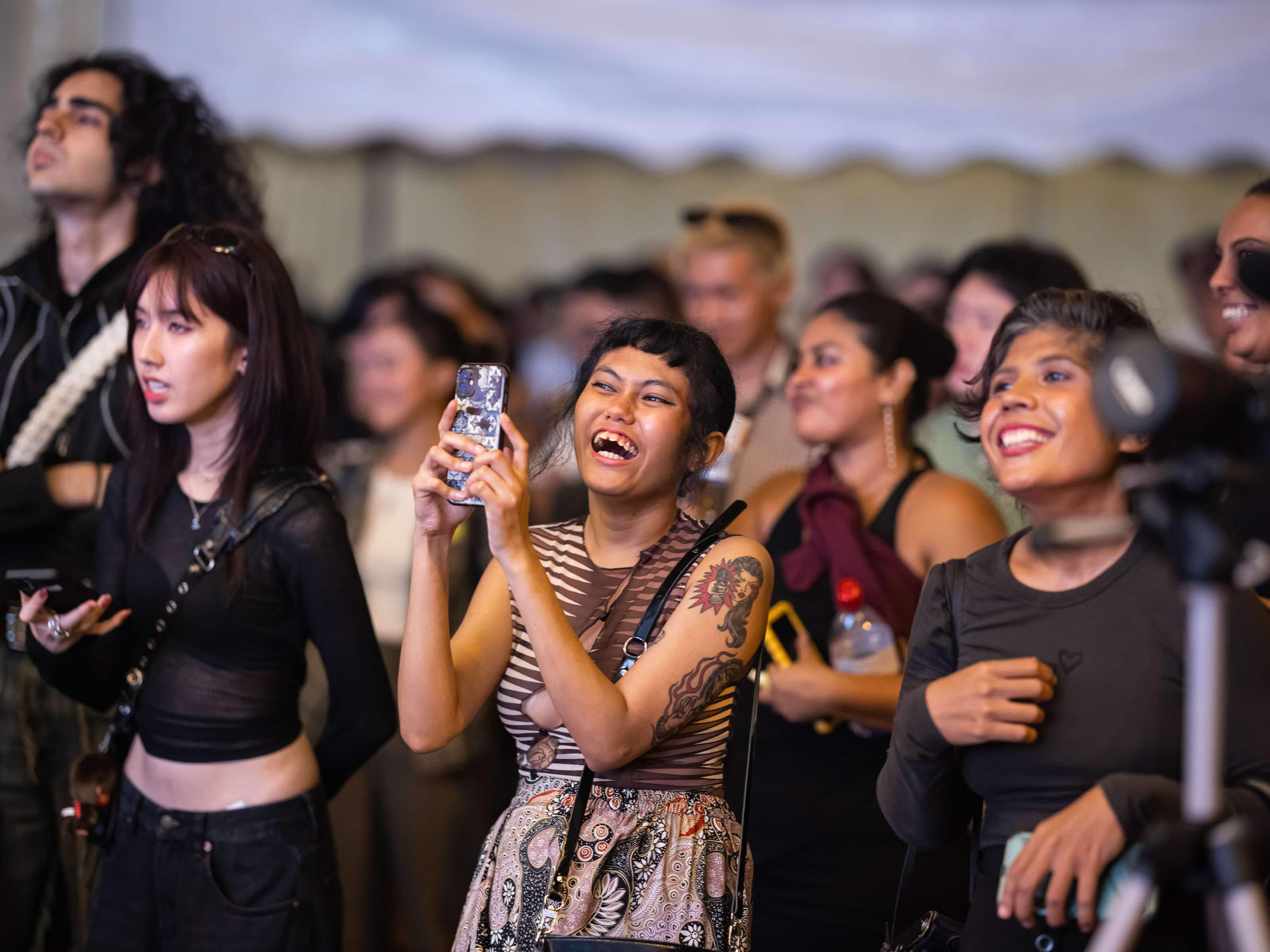 People enjoying a performance and capturing photos