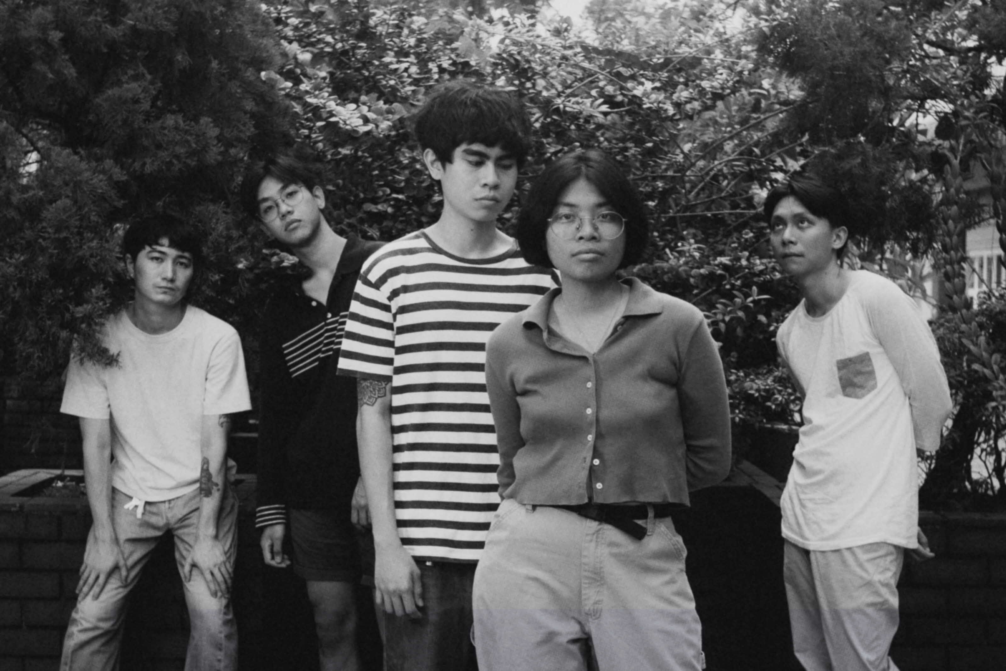 Black and white image of a group of 4 men and 1 woman looking into the camera